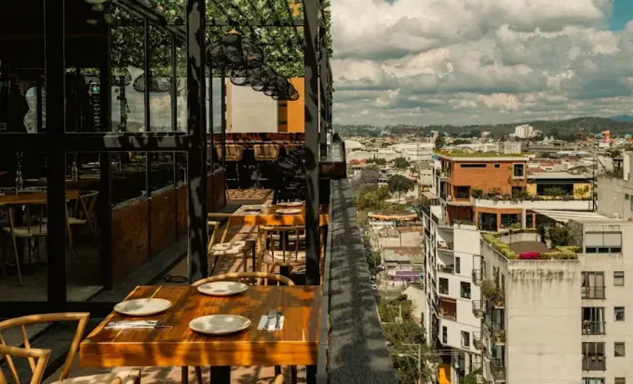 Terraza de Le Sommet con mesas y vista a Ciudad de Guatemala